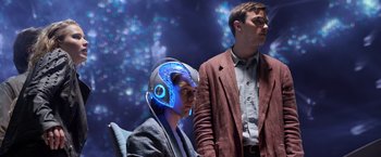 Movie still from “X-Men: Apocalypse” (2016), directed by Bryan Singer – A man wearing a helmet and a man standing next to him wearing a suit; Medium shot, Over the shoulder angle