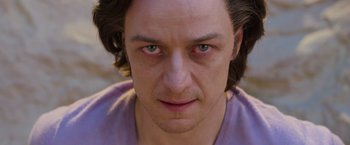 Movie still from “X-Men: Apocalypse” (2016), directed by Bryan Singer – A man's face with green eyes; Close Up shot, Over the shoulder angle