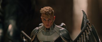 Movie still from “X-Men: Apocalypse” (2016), directed by Bryan Singer – A young man in a futuristic suit is posing for a picture; Close Up shot, Low angle