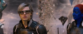 Movie still from “X-Men: Apocalypse” (2016), directed by Bryan Singer – A man in a black and white suit and white glasses; Close Up shot, Over the shoulder angle