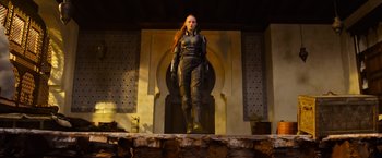 Movie still from “X-Men: Apocalypse” (2016), directed by Bryan Singer – A woman in a black outfit standing on top of a stage; Wide shot, Low angle