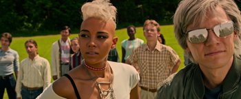 Movie still from “X-Men: Apocalypse” (2016), directed by Bryan Singer – A woman with a shaved head is standing in front of a group of people; Close Up shot, Low angle
