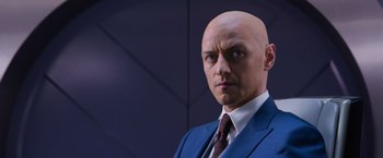 Movie still from “X-Men: Apocalypse” (2016), directed by Bryan Singer – A man in a suit and tie standing in front of a wall; Close Up shot, Over the shoulder angle