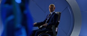 Movie still from “X-Men: Apocalypse” (2016), directed by Bryan Singer – A man in a suit and tie sitting in a chair; Medium shot, Over the shoulder angle