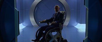 Movie still from “X-Men: Apocalypse” (2016), directed by Bryan Singer – A man in a suit and tie sitting in a wheel chair; Medium shot, Over the shoulder angle