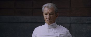 Movie still from “X-Men: The Last Stand” (2006), directed by Brett Ratner – An older man wearing a white shirt and standing in front of a brick wall; Close Up shot, Low angle