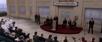 Movie still from “X-Men: The Last Stand” (2006), directed by Brett Ratner – A group of people sitting on a stage in front of an audience; Wide shot, High angle