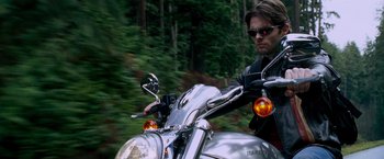 Movie still from “X-Men: The Last Stand” (2006), directed by Brett Ratner – A man riding a motorcycle down a street; Close Up shot, Low angle