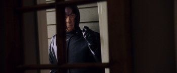 Movie still from “X-Men: The Last Stand” (2006), directed by Brett Ratner – A man in a black costume is looking out of a window; Medium shot, Low angle