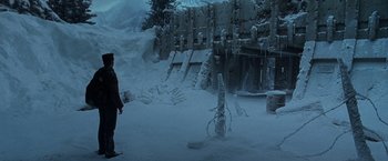 Movie still from “X2” (2003), directed by Bryan Singer – A man standing in front of a snow covered structure; Extreme Wide shot, High angle