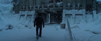 Movie still from “X2” (2003), directed by Bryan Singer – A man with a backpack walking in a snowy area; Wide shot, High angle