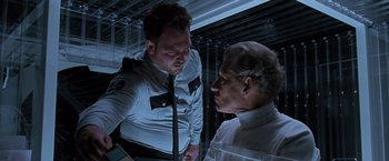Movie still from “X2” (2003), directed by Bryan Singer – A man and a man in a white shirt and tie talking to each other; Medium shot, Low angle