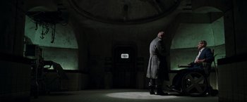 Movie still from “X2” (2003), directed by Bryan Singer – A man standing in a dark room next to a window; Wide shot, Low angle