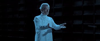 Movie still from “X2” (2003), directed by Bryan Singer – An older man in a white lab coat is holding his hands out; Medium shot, Low angle