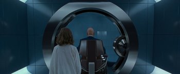 Movie still from “X2” (2003), directed by Bryan Singer – A man and a woman are looking into a circular window; Medium shot, Over the shoulder angle