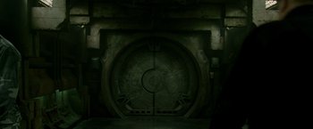 Movie still from “X2” (2003), directed by Bryan Singer – An open door in a dark room with lights on; Wide shot, High angle