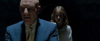 Movie still from “X2” (2003), directed by Bryan Singer – A man and a girl standing next to each other in a dark room; Close Up shot, Low angle