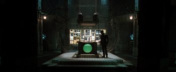 Movie still from “X2” (2003), directed by Bryan Singer – A man standing in front of a television set; Wide shot, High angle