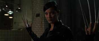 Movie still from “X2” (2003), directed by Bryan Singer – A woman in a black leather jacket holding a knife; Close Up shot, Low angle