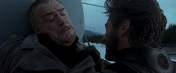 Movie still from “X2” (2003), directed by Bryan Singer – A man holding an umbrella over another man's face; Close Up shot, Low angle