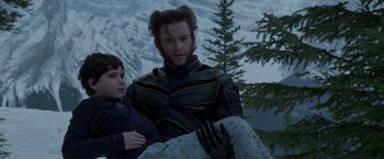 Movie still from “X2” (2003), directed by Bryan Singer – A man holding a boy on his back in front of a snowy mountain; Medium shot, Low angle