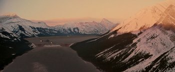 Movie still from “X2” (2003), directed by Bryan Singer – A view of a mountain range and a body of water at sunset; Extreme Wide shot, High angle