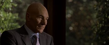 Movie still from “X2” (2003), directed by Bryan Singer – A man in a suit and tie looking to his left; Close Up shot, Over the shoulder angle