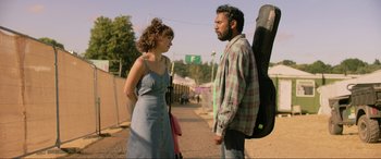 Movie still from “Yesterday” (2019), directed by Danny Boyle – A man and a woman standing next to each other on a dirt road; Medium shot, Over the shoulder angle