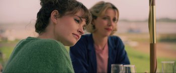 Movie still from “Yesterday” (2019), directed by Danny Boyle – Two women sitting at a table with a glass of water; Close Up shot, Over the shoulder angle