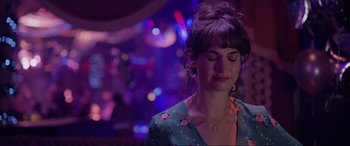 Movie still from “Yesterday” (2019), directed by Danny Boyle – A woman with her eyes closed in front of lights; Close Up shot, Over the shoulder angle