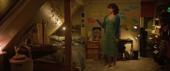 Movie still from “Yesterday” (2019), directed by Danny Boyle – A woman standing in front of a bed in a room; Wide shot, High angle