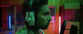 Movie still from “Yesterday” (2019), directed by Danny Boyle – A man with a beard wearing headphones looking to the side; Close Up shot, Low angle