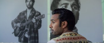 Movie still from “Yesterday” (2019), directed by Danny Boyle – A person with a gun in his hand; Close Up shot, Over the shoulder angle