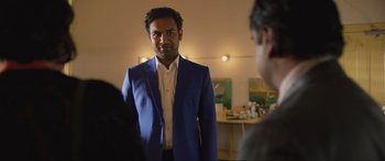 Movie still from “Yesterday” (2019), directed by Danny Boyle – A man in a blue suit standing in front of a mirror; Medium shot, Over the shoulder angle