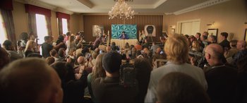 Movie still from “Yesterday” (2019), directed by Danny Boyle – A crowd of people in a large room with microphones; Extreme Wide shot, Over the shoulder angle