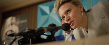 Movie still from “Yesterday” (2019), directed by Danny Boyle – A person at a podium with microphones; Close Up shot, Low angle