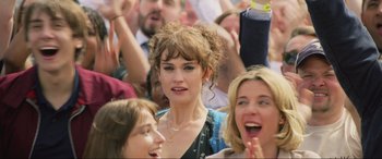 Movie still from “Yesterday” (2019), directed by Danny Boyle – A group of people that are standing in a crowd; Close Up shot, Over the shoulder angle