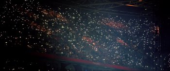 Movie still from “Yesterday” (2019), directed by Danny Boyle – A crowd of people in a stadium at night with cell phones in their hands; Extreme Wide shot, High angle