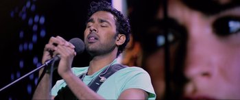 Movie still from “Yesterday” (2019), directed by Danny Boyle – A man with a beard is singing into a microphone; Close Up shot, Low angle