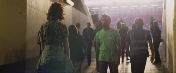 Movie still from “Yesterday” (2019), directed by Danny Boyle – A group of people walking down a sidewalk; Medium shot, Over the shoulder angle