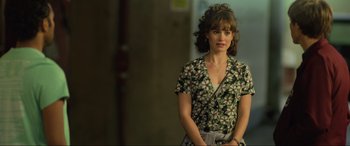 Movie still from “Yesterday” (2019), directed by Danny Boyle – A woman in a floral shirt standing next to a wall; Medium shot, Over the shoulder angle