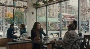 Movie still from “You Hurt My Feelings” (2023), directed by Nicole Holofcener – Two people sitting at a table in front of a store window; Wide shot, Over the shoulder angle