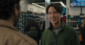 Movie still from “You Hurt My Feelings” (2023), directed by Nicole Holofcener – A man in a green jacket smiling for the camera; Close Up shot, Over the shoulder angle