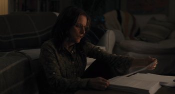 Movie still from “You Hurt My Feelings” (2023), directed by Nicole Holofcener – A woman sitting at a table looking at a laptop; Medium shot, Over the shoulder angle