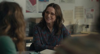 Movie still from “You Hurt My Feelings” (2023), directed by Nicole Holofcener – A woman sitting at a table in front of papers; Medium shot, Over the shoulder angle