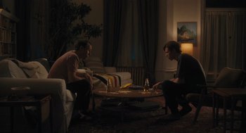 Movie still from “You Hurt My Feelings” (2023), directed by Nicole Holofcener – Two people sitting on a couch in a living room; Wide shot, Over the shoulder angle