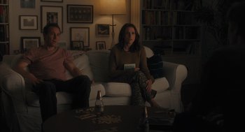 Movie still from “You Hurt My Feelings” (2023), directed by Nicole Holofcener – Two people sitting on a white couch in a living room; Medium shot, Over the shoulder angle