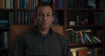 Movie still from “You Hurt My Feelings” (2023), directed by Nicole Holofcener – A man sitting in front of a book shelf; Medium shot, Over the shoulder angle