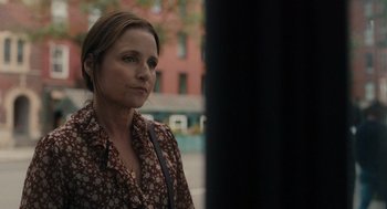 Movie still from “You Hurt My Feelings” (2023), directed by Nicole Holofcener – A person standing near a pole; Close Up shot, Over the shoulder angle