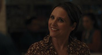 Movie still from “You Hurt My Feelings” (2023), directed by Nicole Holofcener – A woman smiling and looking to her left; Close Up shot, Over the shoulder angle